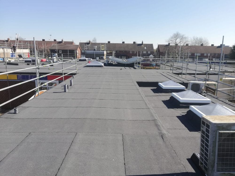 Completed roof at Phoenix Academy with the existing solar array reinstated over the new waterproofing